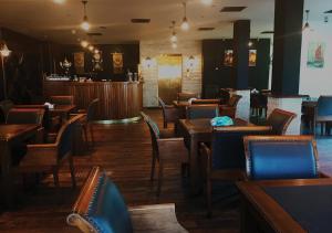 伊尔比德Ajnadeen Hotel的一间带木桌椅的餐厅和一间酒吧