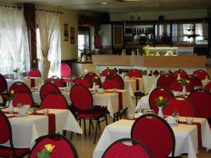 明斯特艾玛迪斯城市酒店的用餐室配有桌椅和红色椅子