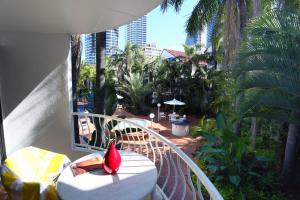黄金海岸圣特罗佩度假酒店的阳台配有桌子和红花