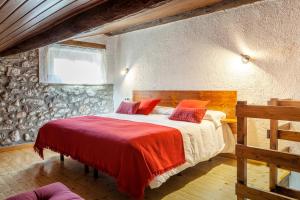 贝尔维尔德赛当亚Hotel Cal Rei de Talló的一间卧室配有一张带红色枕头的大床