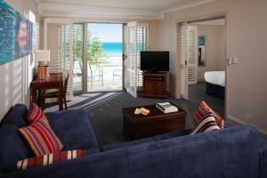 珀斯海贝士嘉堡酒店的客厅配有蓝色的沙发和电视