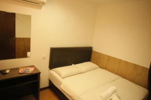 麻坡N K Hotel的一间小卧室,配有床和床头柜