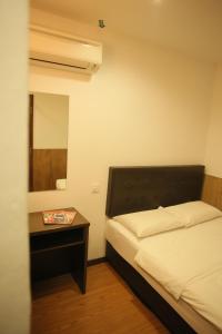 麻坡N K Hotel的一间卧室配有一张床和一张带镜子的桌子