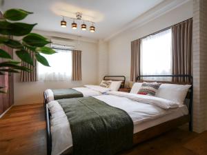 大阪Sakura Coco Residence的一间卧室设有两张床和窗户。