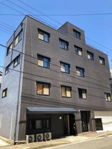 大阪Sakura Coco Residence的灰色的建筑,街上有窗户