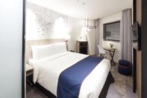 首尔首尔弘大智选假日酒店的一间卧室配有一张带蓝色毯子的大床