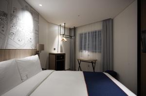 首尔首尔弘大智选假日酒店的配有一张床和一张书桌的酒店客房