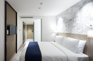 首尔首尔弘大智选假日酒店的酒店客房设有一张大床和壁画