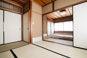 金泽Ryu TABI-NE的一间玻璃门的房间,里面设有一张床