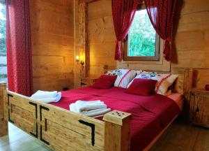 布科维纳-塔钱斯卡Bukowiańska Ostoja的一间卧室配有一张大木床和红色床单