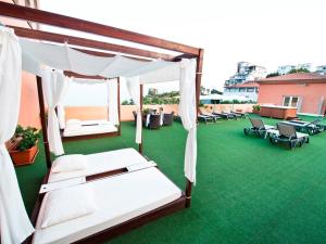 阿尔姆尼卡巴西亚热带酒店的绿色草坪上的房间,配有两张床和椅子
