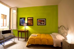 锡耶纳卢佩住宿加早餐旅馆的一间卧室设有一张带床铺的绿色墙壁