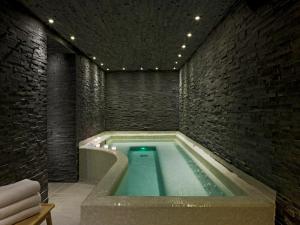 夏蒙尼-勃朗峰芳兹尼 - 尚莫酒店的砖墙房间的游泳池