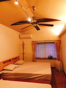 冈山HimawariRyokanひまわり旅館的一间卧室配有吊扇和一张床