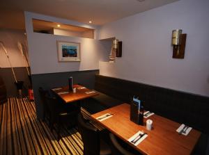 洛西茅斯Firth Hotel & Restaurant的餐厅内带两张桌子的用餐室