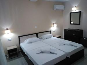 瓦西里科斯Zante Yliessa的一间卧室配有两张带白色床单和枕头的床。