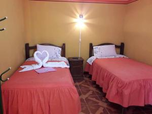 乌尤尼Hostal "La Roca" Uyuni的两张睡床彼此相邻,位于一个房间里