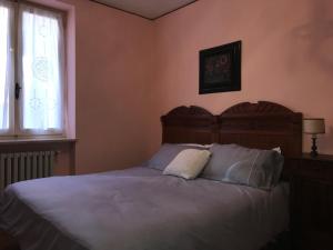 拉莫拉Bed & Roses “Gege”的一间卧室配有一张带木制床头板的床和窗户。