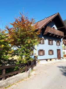 GaichtFerienhaus Alpenglück的白色的房子,有木栅栏和一棵树
