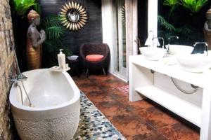 沙努尔竹月别墅的浴室配有两个盥洗盆和浴缸。