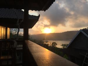 蓝梦岛Sunday Huts Lembongan的从房子的阳台上可欣赏到日落美景