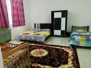 马六甲Faeyz Homestay Melaka的一间带两张床的卧室和地毯