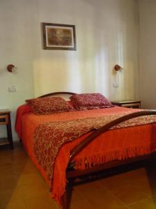 乌斯帕亚塔卡瓦尼亚斯廊奎兰开山林小屋的一间卧室配有一张带红色床单和枕头的床。