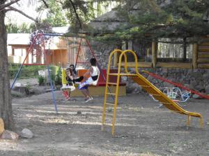 乌斯帕亚塔卡瓦尼亚斯廊奎兰开山林小屋的两个孩子在游乐场玩秋千