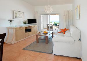 伊斯费古耶拉尔海滩阿雷纳多尔旅馆的客厅配有白色的沙发和桌子