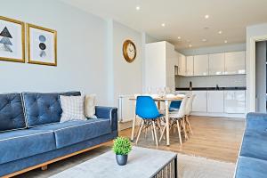 伦敦Elegant Plus Luxury Apartments的客厅配有蓝色的沙发和桌子