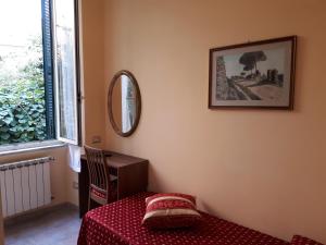 罗马亚提斯酒店的卧室配有桌子和墙上的镜子