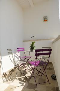 鲁沃迪普利亚La Puglia di Claudia的客房内的2把紫色椅子和1张桌子
