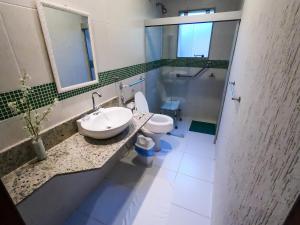 萨夸雷马Pousada das Garças的一间带水槽、卫生间和镜子的浴室