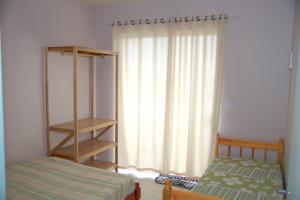 伊塔波阿Residencial Oceano Azul的一间卧室配有床和带窗帘的窗户