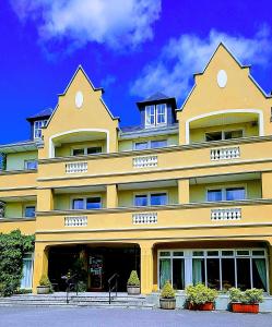 基拉尼伯爵宫酒店的一座黄色的大建筑,上面有窗户
