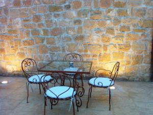 阿尔卡尼斯维拉蒙特酒店的砖墙前的一张桌子和四把椅子