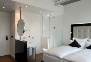 杜塞尔多夫INNSiDE by Meliá Düsseldorf Hafen的一间卧室配有床、镜子和水槽