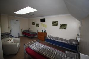 巴拉特Ballater Hostel的宿舍间设有两张双层床和一张沙发。