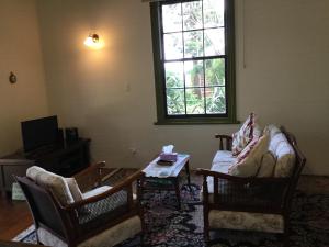 蒂阿瓦穆图老学校乡村民宿的客厅配有两把椅子和一张桌子