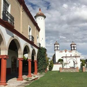 San Lorenzo SoltepecEx-Hacienda San Buenaventura的一座在院子里有两座白色塔楼的建筑