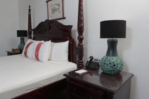 蒙特哥贝阿尔塔蒙特西酒店的一间卧室配有一张床和一张桌子上的台灯