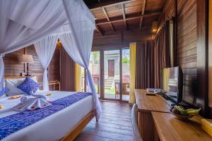 乌鲁瓦图普里潘德瓦度假酒店的一间卧室配有一张床、一张书桌和一台电视