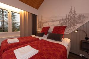 易拉斯加威拉斯利纳酒店的一间卧室配有两张红色和白色床单