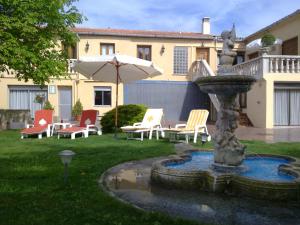 巴尔铁拉Casa Rural Sancho el Fuerte的庭院里的喷泉,配有椅子和遮阳伞