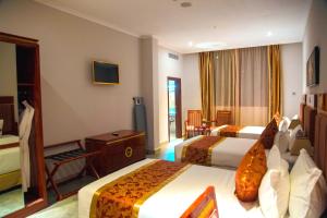 达累斯萨拉姆Tiffany Diamond Hotels LTD - Makunganya的酒店客房设有两张床和电视。