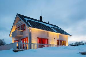 VahtseliinaVasekoja Holiday Center的雪中带红色门的房子