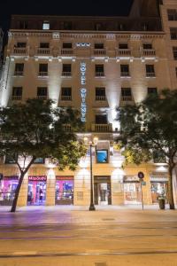 萨拉戈萨东方酒店的一座在晚上有树的建筑