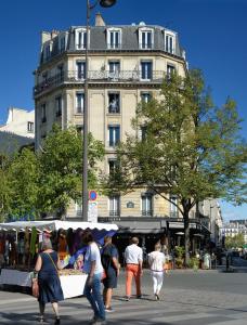 巴黎蒙帕纳斯敖德萨酒店的一群人走在大楼前的市场周围