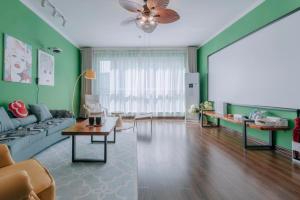 西安西安市莲湖区·汉城湖·路客精品公寓·00172050的客厅设有绿色的墙壁和沙发