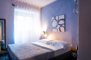 斯培西亚5 Terre Inn Affittacamere的一间卧室配有一张蓝色墙壁的床